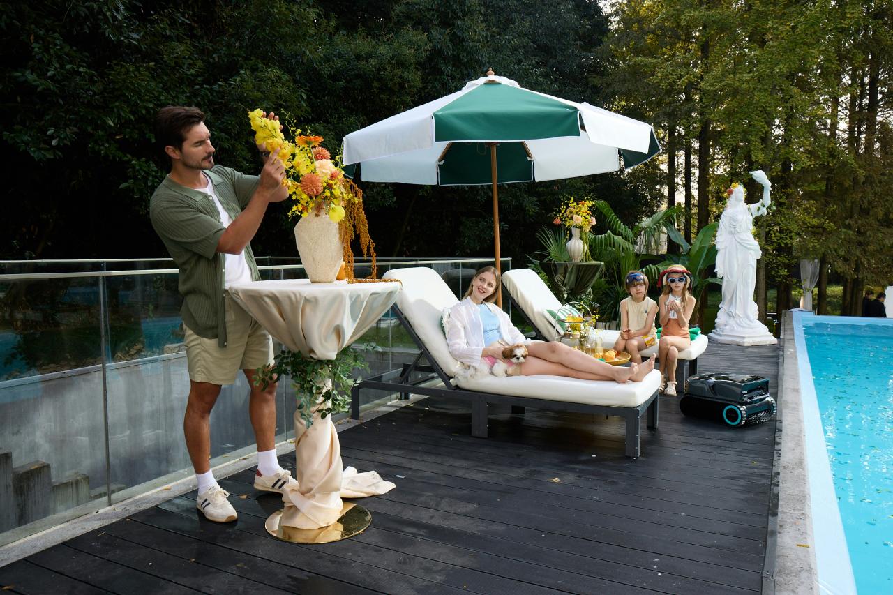 Man arranges flowers by pool with people relaxing