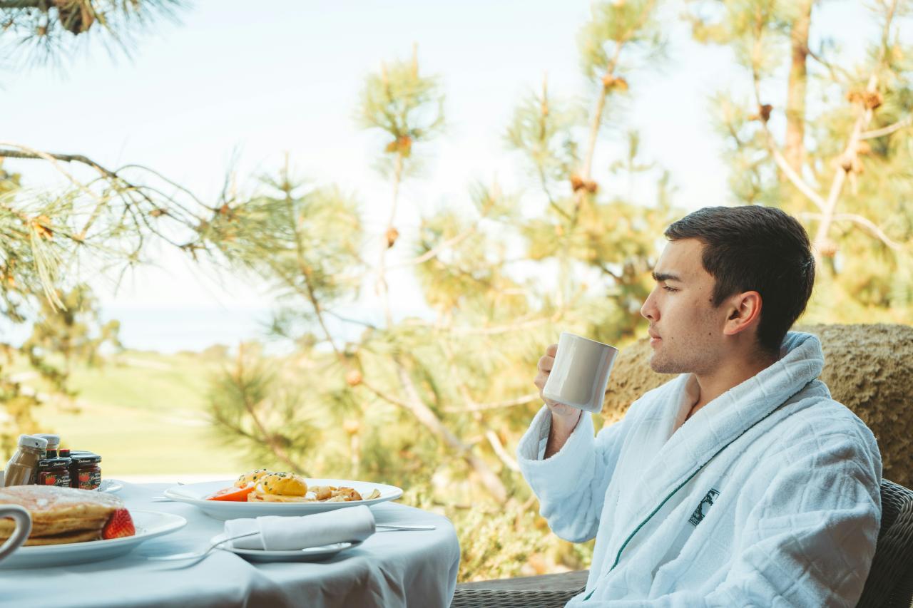 a man sitting at a table with a cup of coffee